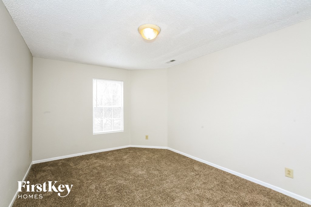 A room with a carpeted floor and a window.