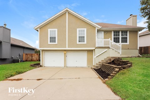 a beige house with a garage and a driveway