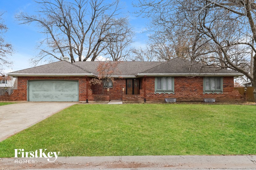 A brick house with a garage door is for sale.