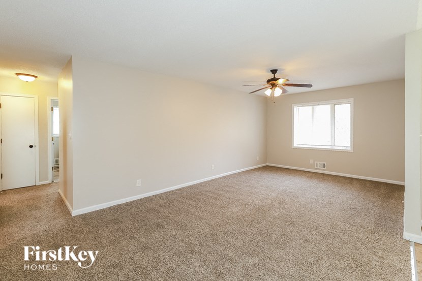 A spacious room with a ceiling fan and a window.