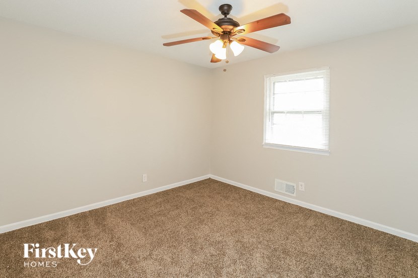 A room with a ceiling fan and a window.