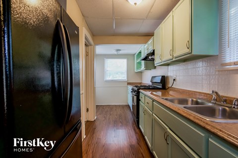 a kitchen with a black refrigerator and a sink
