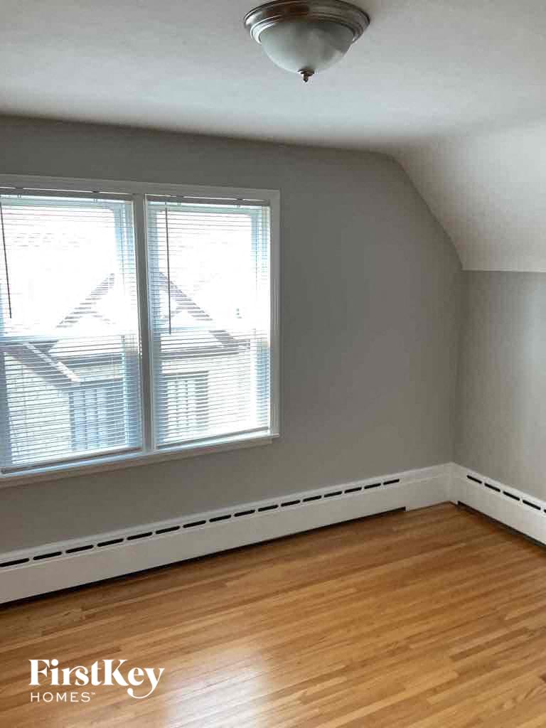 an empty room with a wood floor and two windows