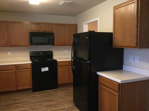 a kitchen with black appliances and wooden cabinets
