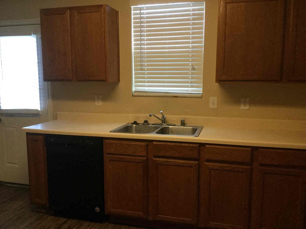 an empty kitchen with a sink and a window