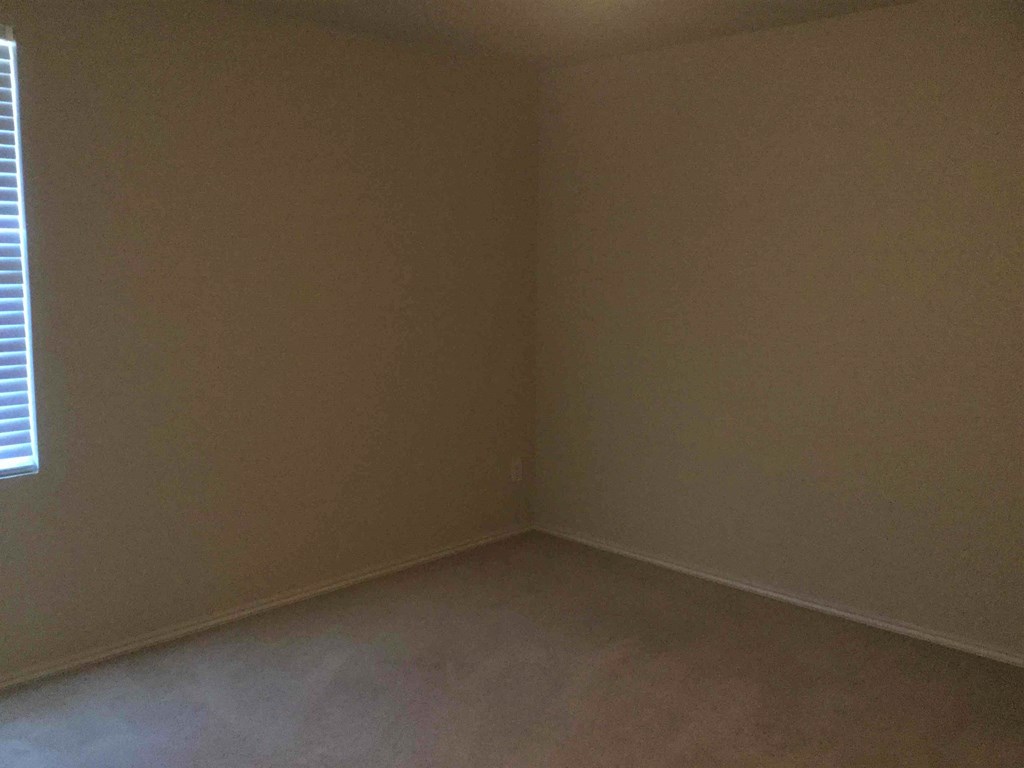 an empty room with white walls and a window