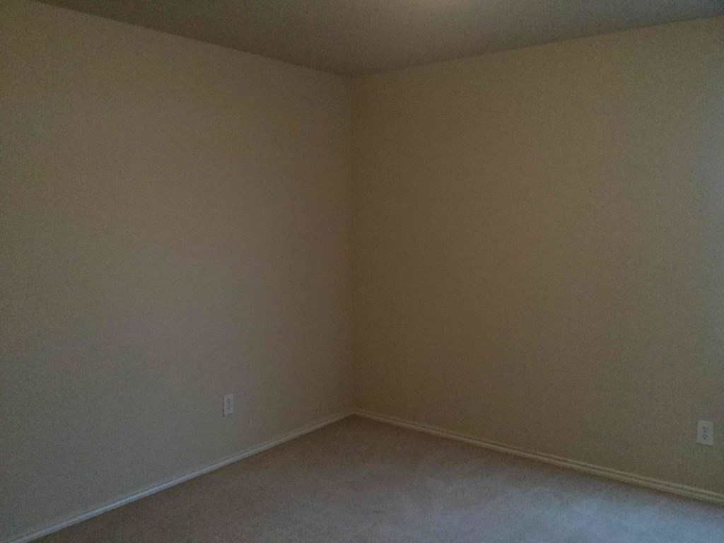 an empty room with beige walls and white floors