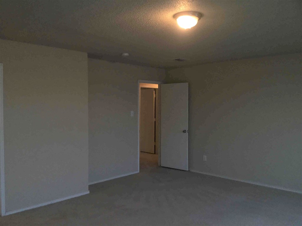 an empty living room with a door to a closet
