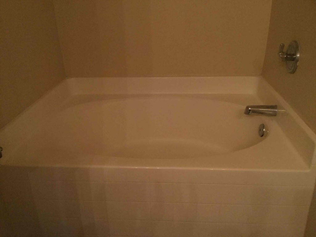 a bath tub in a bathroom with white tiles