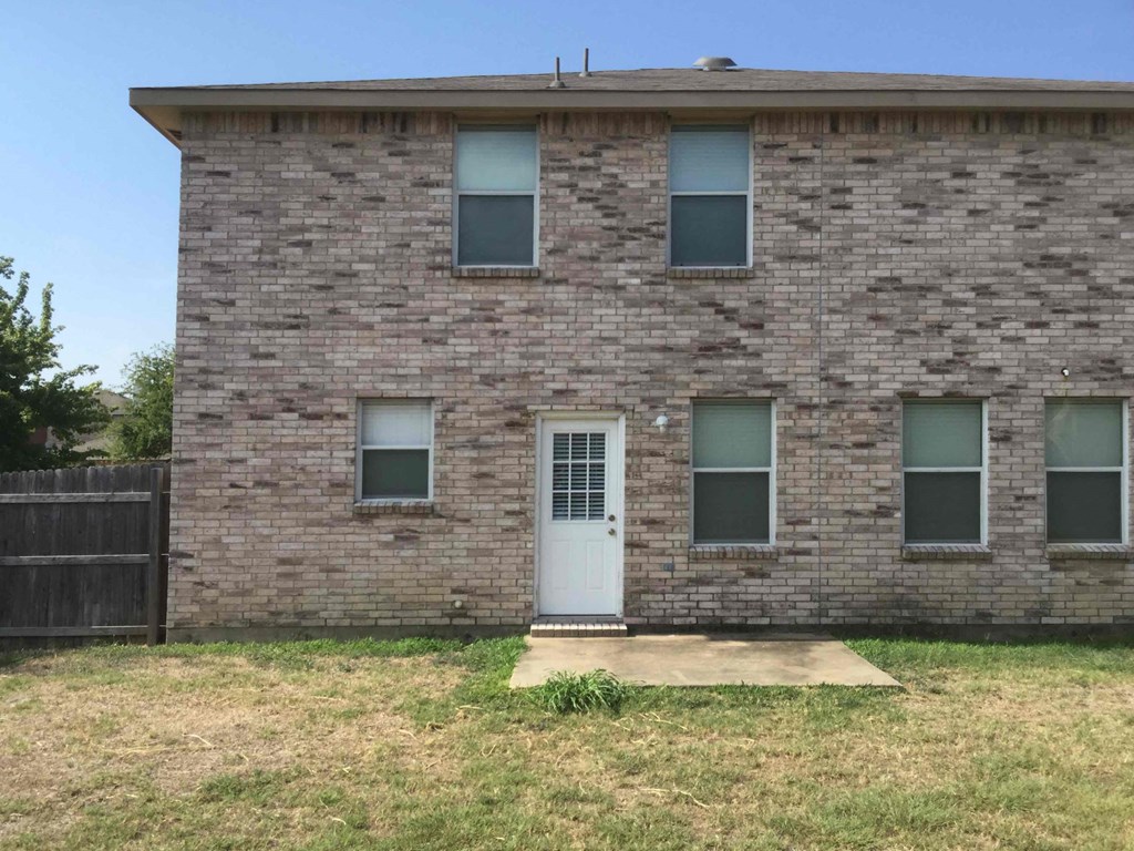 an old brick building with a white door and windows