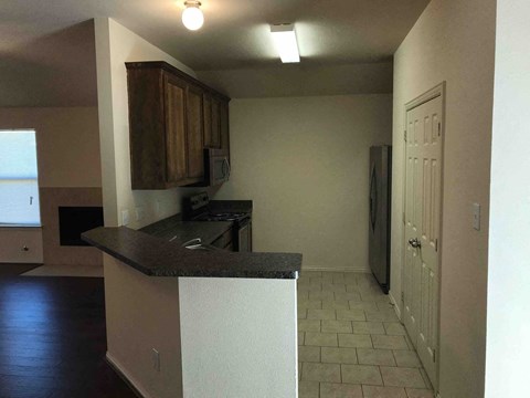 A kitchen with a black counter top and white cabinets.