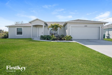 a white house with a lawn and a driveway