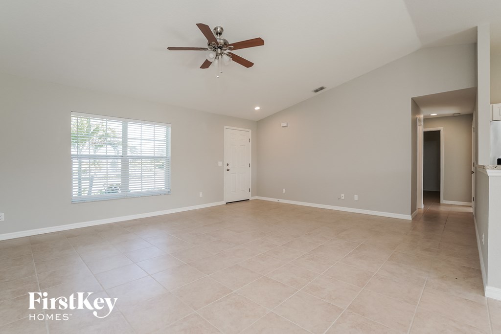 an empty kitchen and living room with a ceiling fan