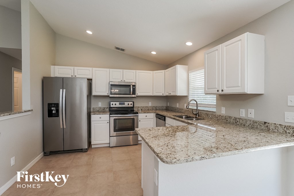 a kitchen with granite counter tops and stainless steel appliances