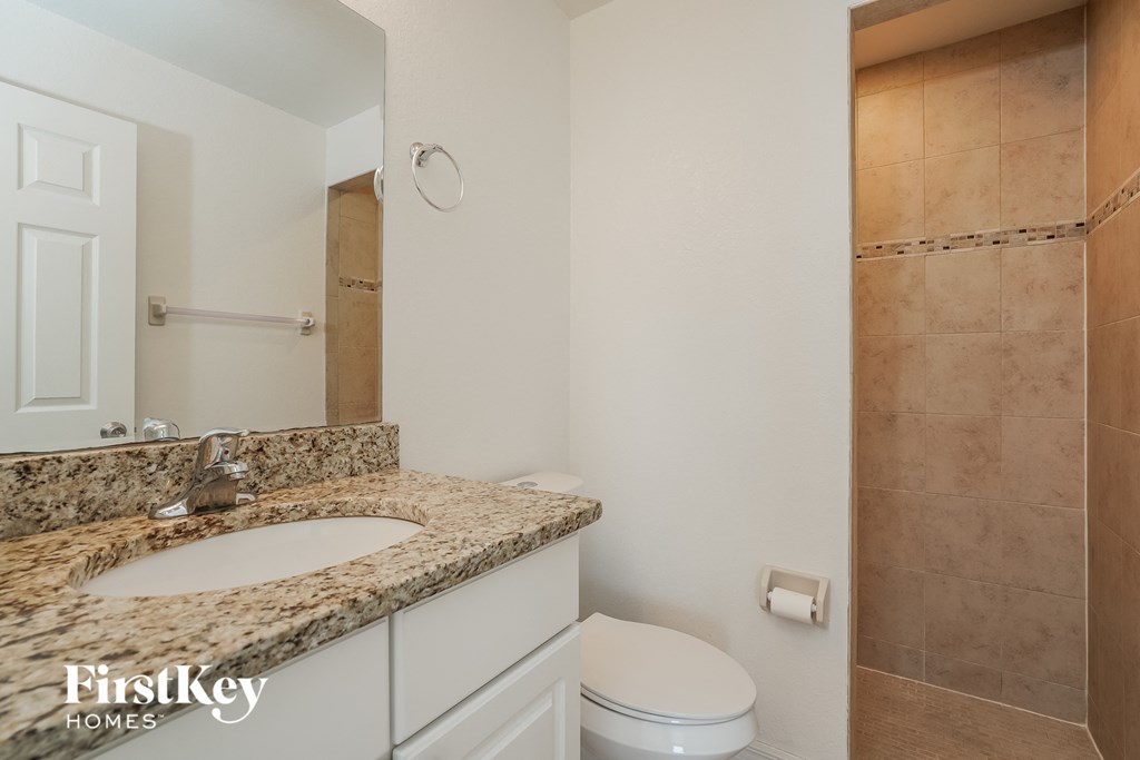 a bathroom with a toilet and a sink and a mirror