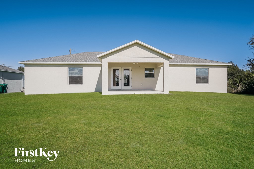 a white house with a green lawn and a blue sky