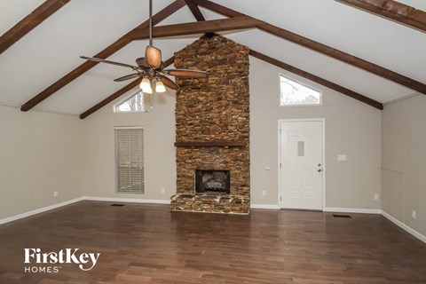the living room of a home with a stone fireplace