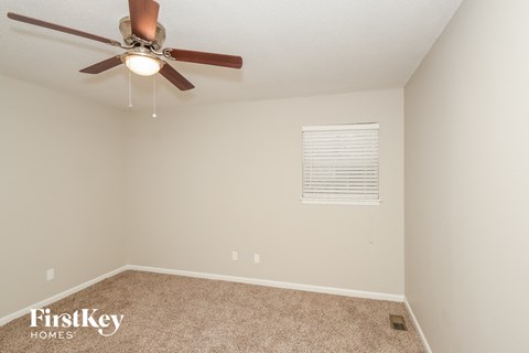 a bedroom with a ceiling fan and a carpeted floor