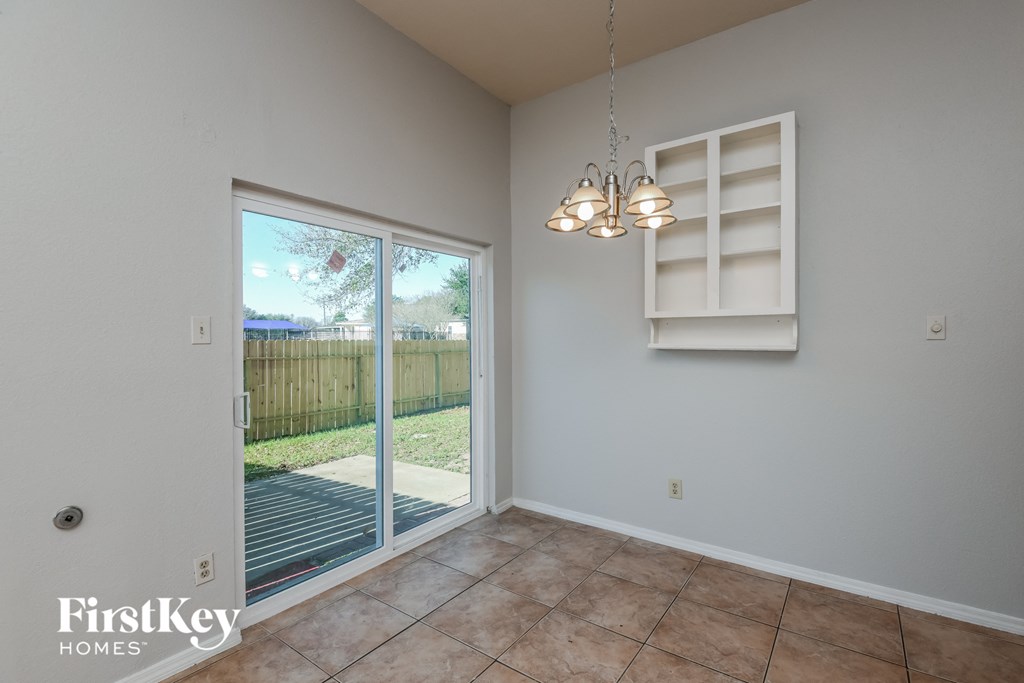 the living room of a house with a large window and a door to the backyard