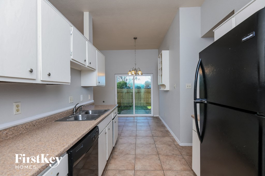 a kitchen with white cabinets and black appliances and a black refrigerator