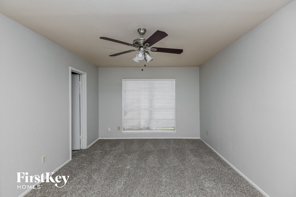 a bedroom with a ceiling fan and a window