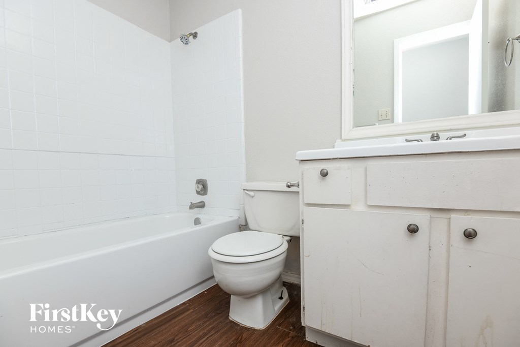 a bathroom with a toilet and a tub and a sink