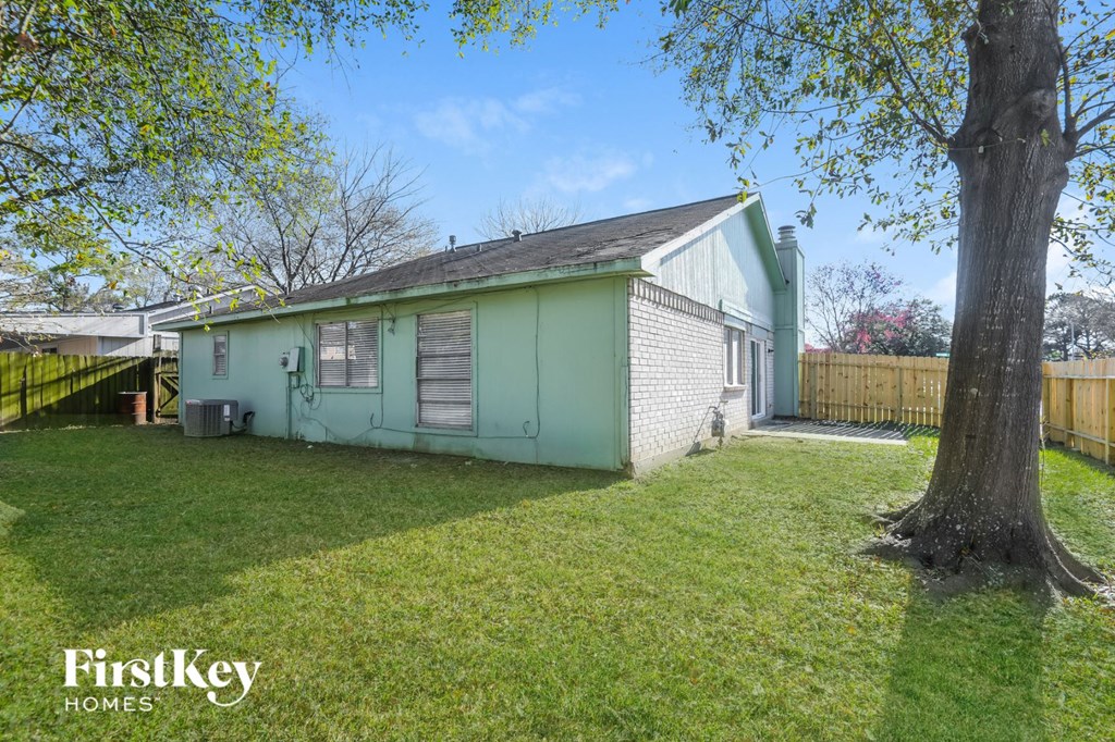 a small green house with a yard and a tree