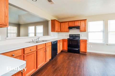 A kitchen with wooden cabinets and a black oven.