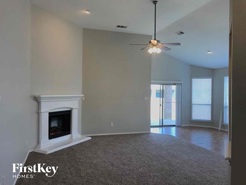 a living room with a fireplace and a ceiling fan