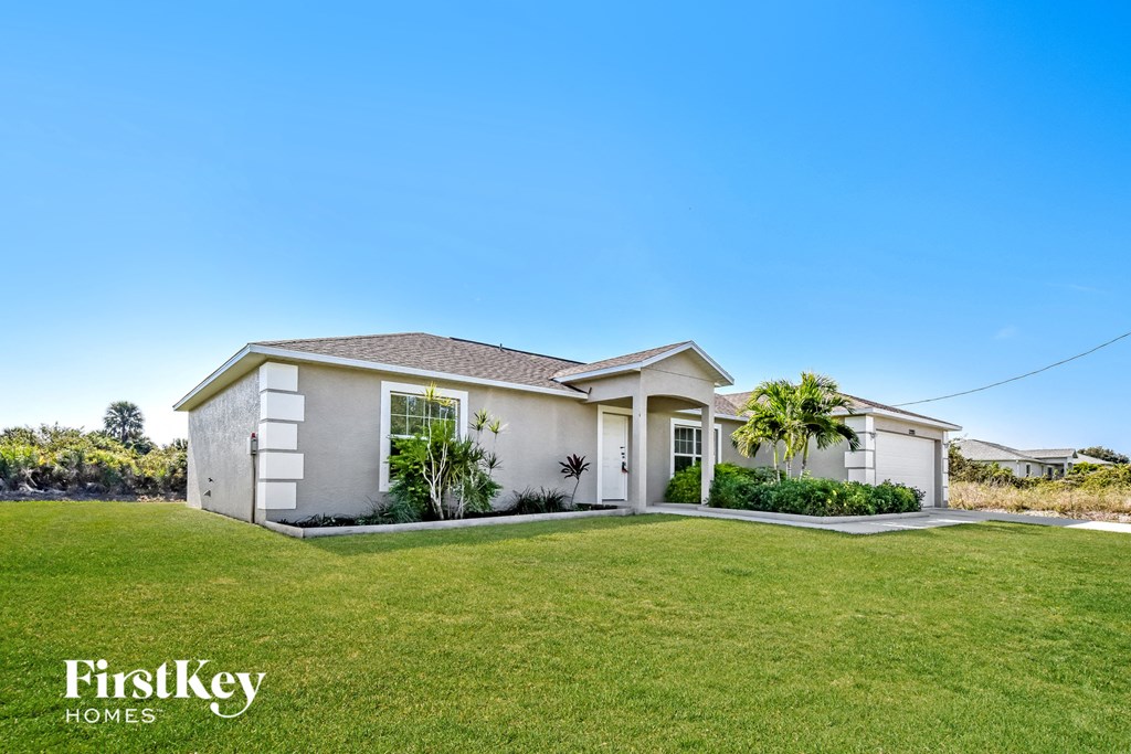 a white house with a lawn and a grassy yard