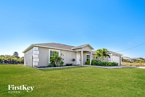 a white house with a lawn and a grassy yard