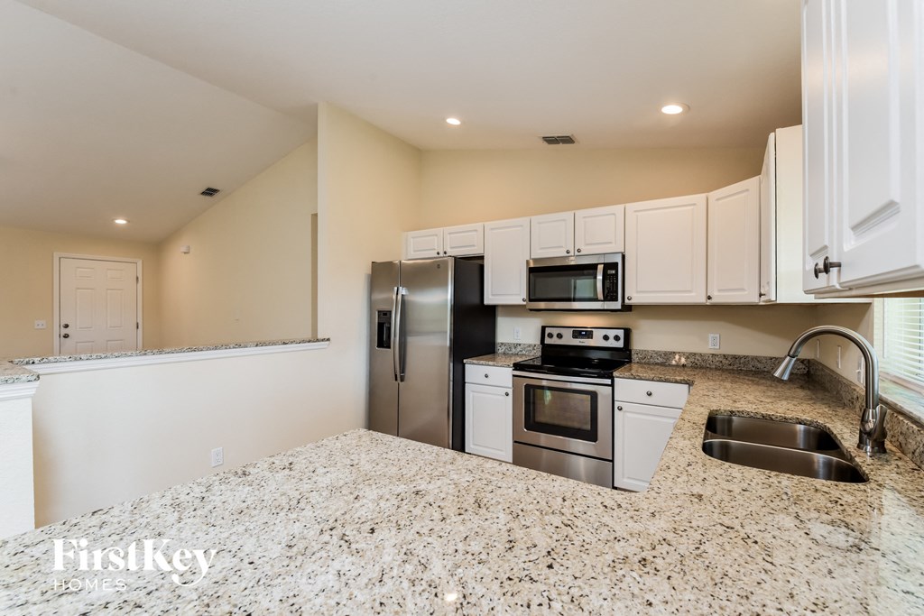 a kitchen with granite counter tops and stainless steel appliances