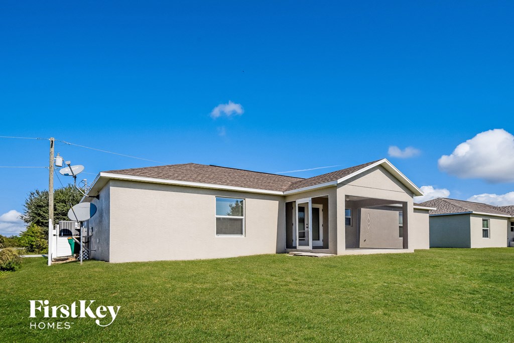 a beige house with a lawn and a blue sky