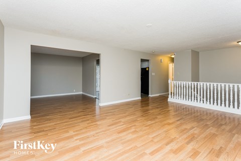 the living room and dining room with wood flooring and a staircase