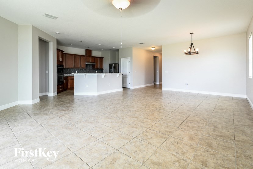 an empty kitchen and living room with a large tile floor