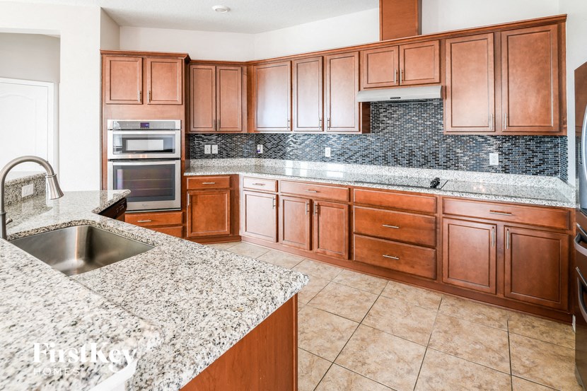 a large kitchen with wooden cabinets and granite counter tops