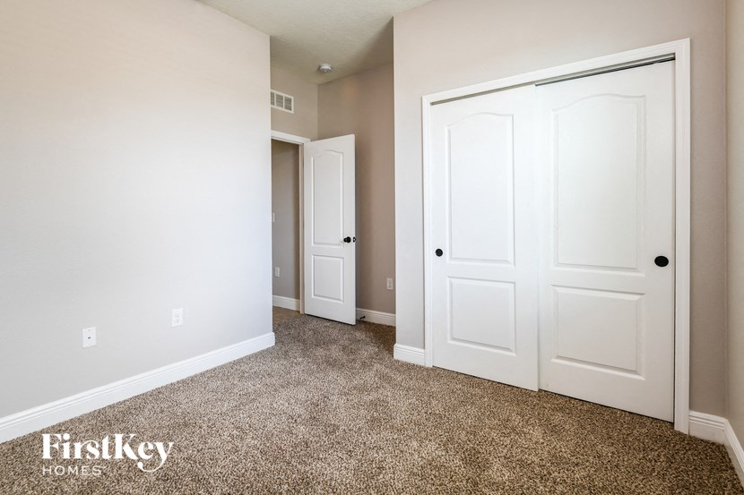 a bedroom with two closets and a carpeted floor