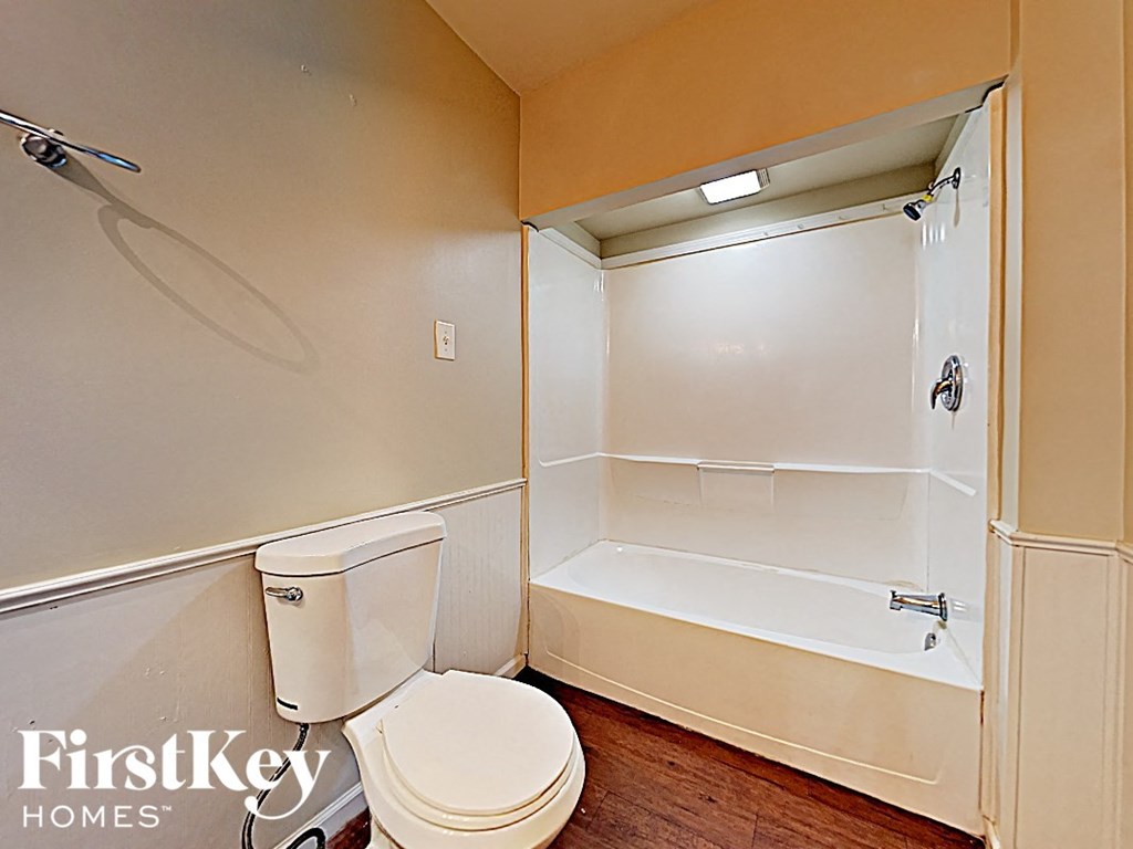 a bathroom with a toilet and a tub and a shower