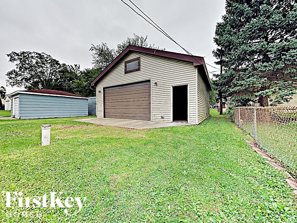 a small garage with a door open in a yard