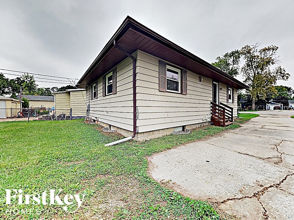 a small white house with a wooden roof on the grass