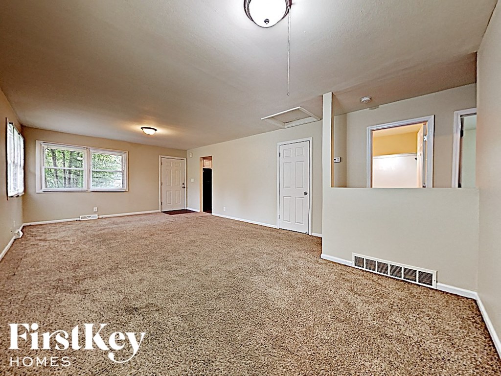 an empty living room with white walls and a carpeted floor