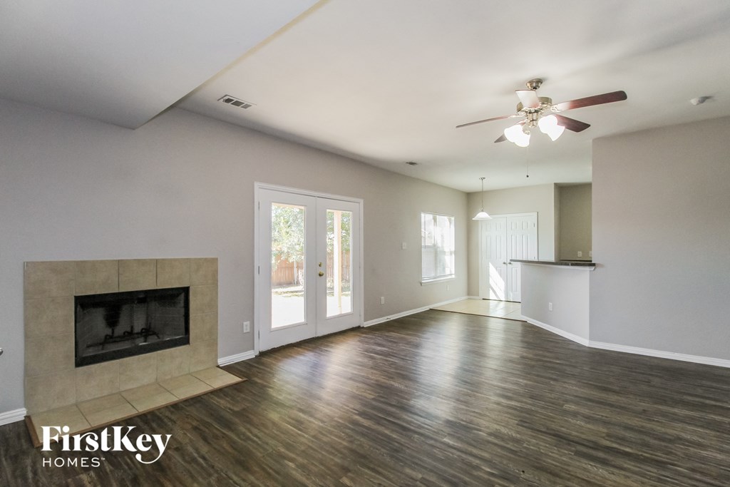 a living room with a fireplace and a ceiling fan
