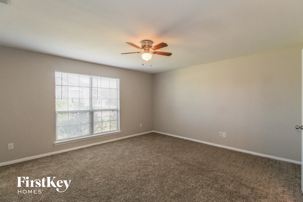 a bedroom with a ceiling fan and a window