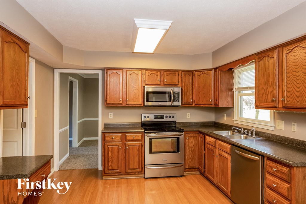 a kitchen with wooden cabinets and stainless steel appliances