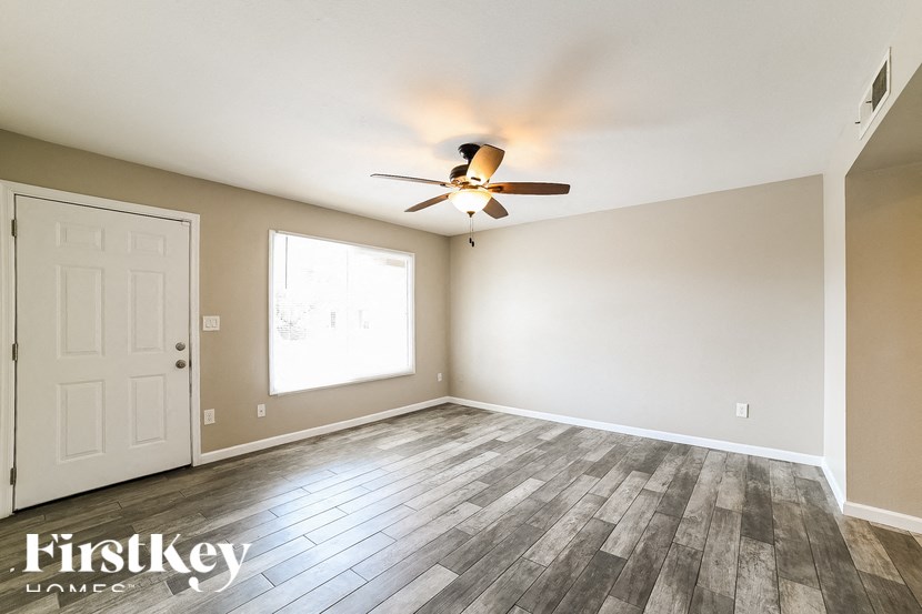 a living room with wood floors and a ceiling fan