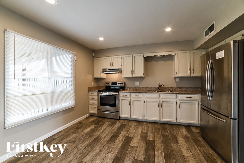 a kitchen with white cabinets and stainless steel appliances