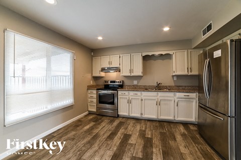 a kitchen with white cabinets and stainless steel appliances