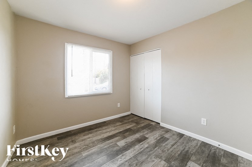 a bedroom with wood flooring and a window