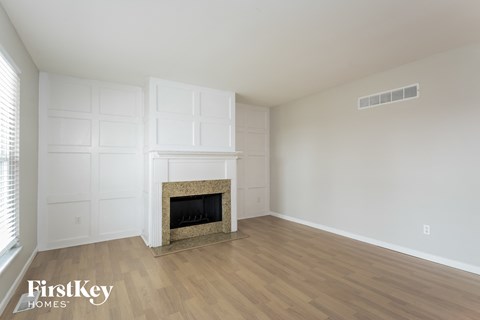 A room with a fireplace and wooden floors.