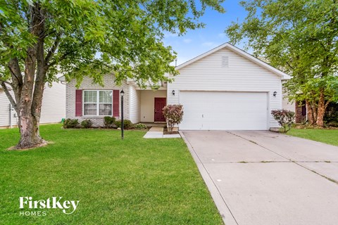 a white house with red doors and a driveway